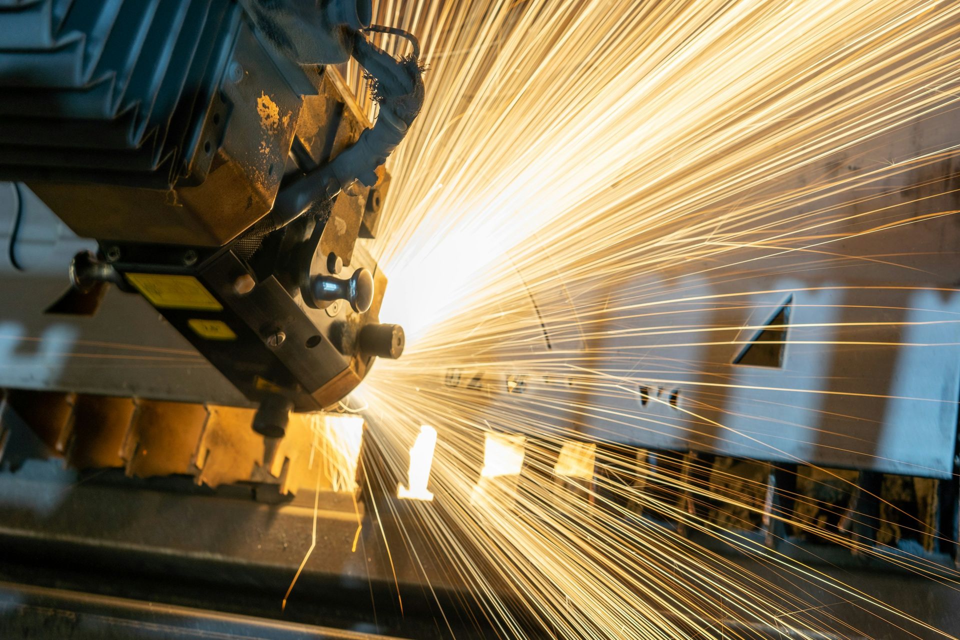 Laser cutter throwing sparks across sheet metal